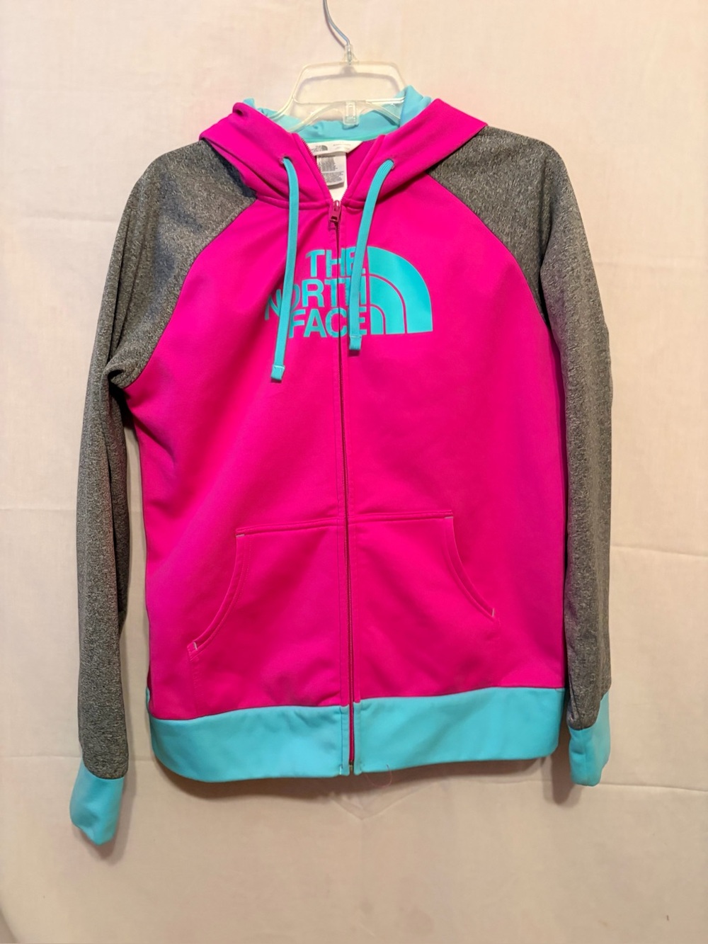 The North Face full-zip hooded sweatshirt in pink, gray, and turquoise.